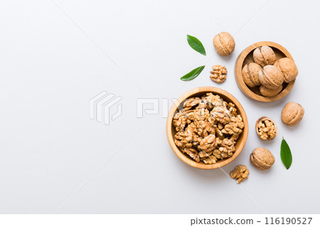 Walnut kernel halves, in a wooden bowl. Close-up, from above on colored background. Healthy eating Walnut concept. Super foods with copy space Walnut kernel halves, in a wooden bowl. Close-up, from above on colored background. Healthy eating Walnut concept. Super foods with copy space 116190527