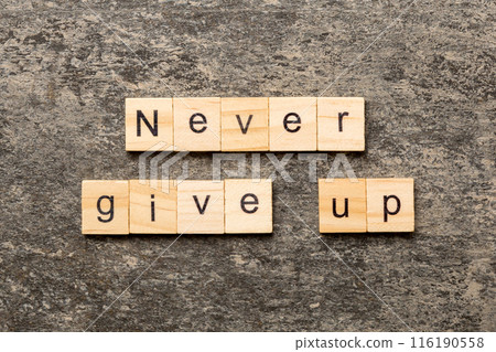 never give up word written on wood block. never give up text on cement table for your desing, concept 116190558