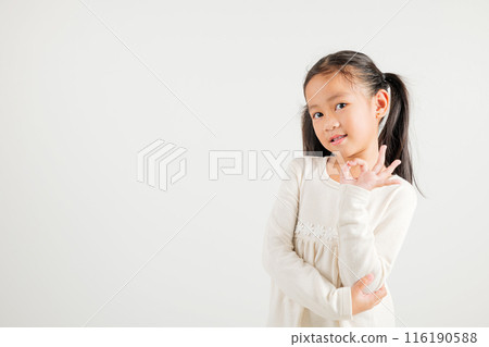 Exuberant young kid girl showcases the OK sign with an optimistic smile, conveying agreement and positivity isolated on a white background, ideal for your text customization. kindergarten child smile 116190588