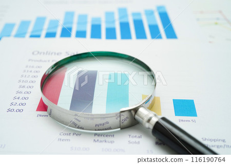Magnifying glass on charts graphs paper. finance business. 116190764