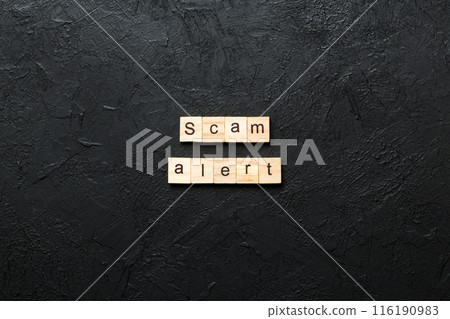 Scam alert word written on wood block. Scam alert text on table, concept Scam alert word written on wood block. Scam alert text on table, concept 116190983