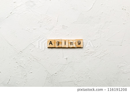 Aging word written on wood block. Aging text on cement table for your desing, concept Aging word written on wood block. Aging text on cement table for your desing, concept 116191208