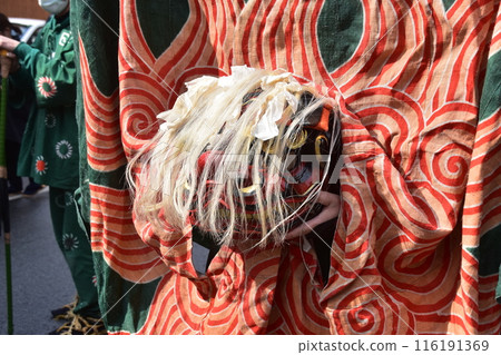 Takayama City, Gifu Prefecture, Japan: Traditional performing arts at the Takayama Spring Festival. Lion dancers parade through the streets in festival costumes, shaking the lion's face. Takayama City, Gifu Prefecture, Japan: Traditional performing arts at the Takayama Spring Festival. Lion dancers parade through the streets in festival costumes, shaking the lion's face. 116191369