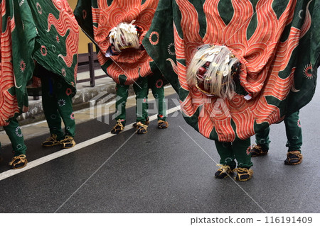日本岐阜縣高山市 — 春季高山節的傳統表演藝術 — 舞獅在小巷中遊行 — 穿著節日服裝的獅子臉搖曳 116191409