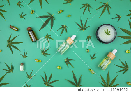 Composition with hemp oil cbd and bottle of oil on green background 116191692