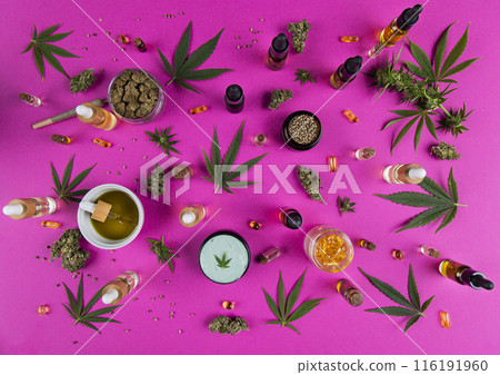 Cannabis leaf with oil bottle and hemp seeds on a pink background Cannabis leaf with oil bottle and hemp seeds on a pink background 116191960