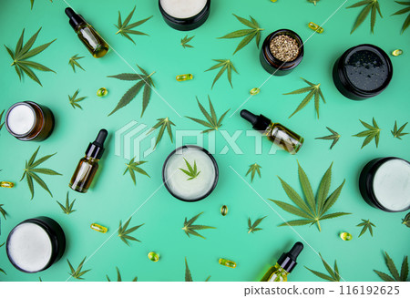 Flat lay composition of marijuana and hemp seeds on green color paper background 116192625