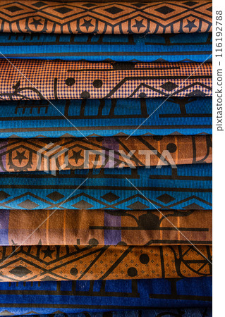Close up of stacked colorful traditional fabric with intricate patterns, including geometric shapes and star motifs, in Turkey. Close up of stacked colorful traditional fabric with intricate patterns, including geometric shapes and star motifs, in Turkey. 116192788
