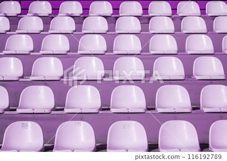 Empty rows of purple stadium seats in an outdoor setting, texture, background. Empty rows of purple stadium seats in an outdoor setting, texture, background. 116192789