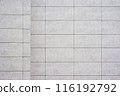 Close up of a tiled wall with a grid pattern, featuring light gray tiles and dark grout lines, as texture, background. 116192792