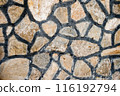 Close up of a stone wall with irregularly shaped stones and dark mortar lines, texture, background. 116192794