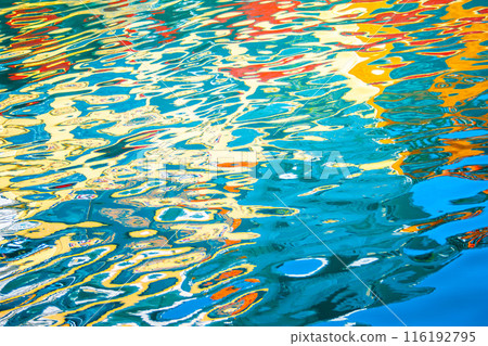 Colorful reflections on water creating an abstract pattern with vibrant hues of blue, yellow, red, and green. Colorful reflections on water creating an abstract pattern with vibrant hues of blue, yellow, red, and green. 116192795