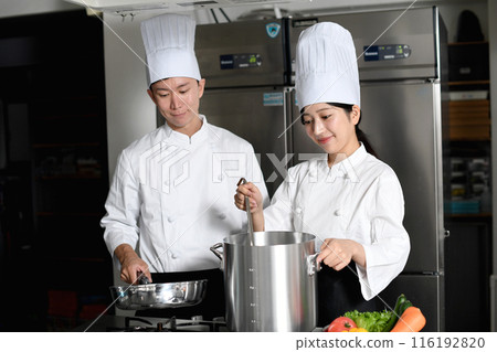 Young asian male and female chefs cooking in the kitchen Young asian male and female chefs cooking in the kitchen 116192820