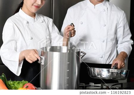 Young asian male and female chefs cooking in the kitchen Young asian male and female chefs cooking in the kitchen 116192823