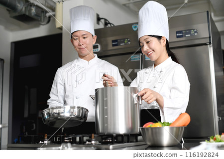 Young asian male and female chefs cooking in the kitchen Young asian male and female chefs cooking in the kitchen 116192824