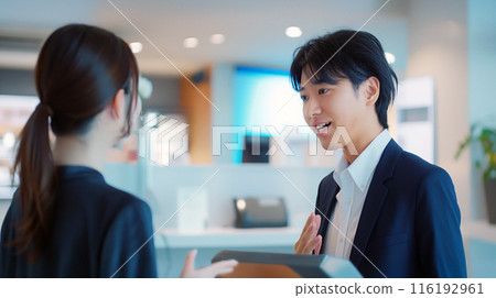 一位男士在商店裡向一位女士解釋產品 116192961