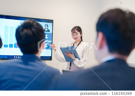 A young female employee giving a presentation at a remote meeting 116193269