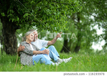 Portrait of senior couple sitting on the grass in the park Portrait of senior couple sitting on the grass in the park 116193978