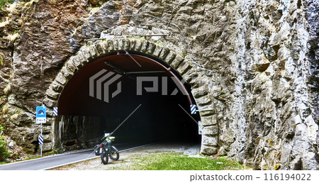 fat bicycle parked at the entrance of a stone tunnel 116194022