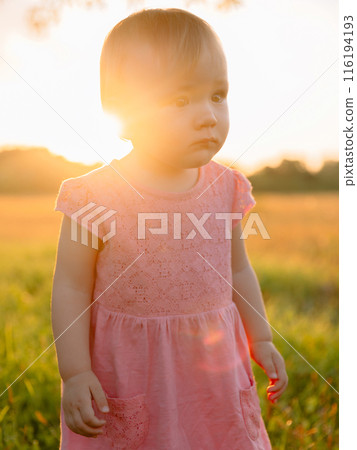 Portrait of infant girl in pink dress with sunset tones. Portrait of infant girl in pink dress with sunset tones. 116194193