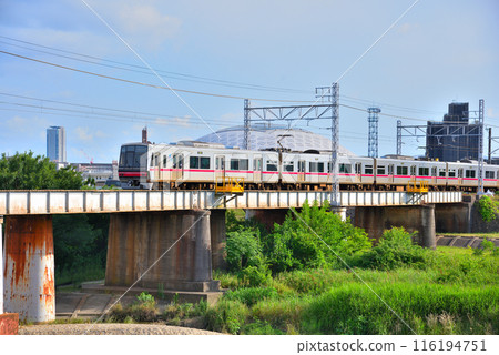 Aichi Prefecture: Nagoya cityscape - A train on the Meitetsu Seto Line crossing the Yatagawa Bridge 116194751