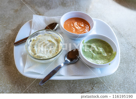 Red mojo, green mojo, garlic sauce. Traditional Tenerife dipping sauces, local cuisine, condiment tray Red mojo, green mojo, garlic sauce. Traditional Tenerife dipping sauces, local cuisine, condiment tray 116195190