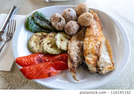 Papas arrugadas sea water boiled potatoes, grilled fish and vegetables, red mojo, green mojo, dining table Papas arrugadas sea water boiled potatoes, grilled fish and vegetables, red mojo, green mojo, dining table 116195192