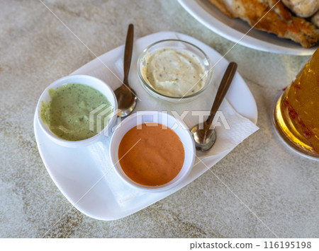 Red mojo, green mojo, garlic sauce. Traditional Tenerife dipping sauces, local cuisine, condiment tray 116195198
