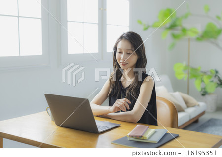 A young woman teleworking in the living room 116195351
