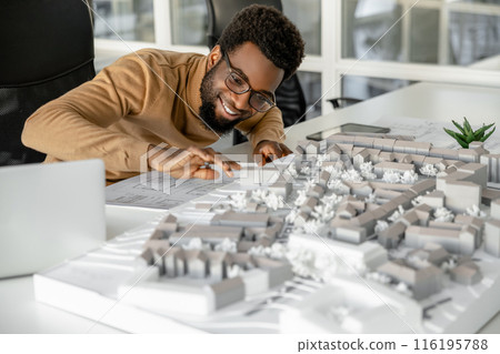 Architect working on miniature project and looking inspired 116195788