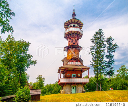 Jurkovic Lookout Tower - wooden lookout tower stands tall in a grassy clearing, surrounded by trees. The tower is adorned with intricate details and a distinctive spire. Roznov pod Radhostem, Czechia Jurkovic Lookout Tower - wooden lookout tower stands tall in a grassy clearing, surrounded by trees. The tower is adorned with intricate details and a distinctive spire. Roznov pod Radhostem, Czechia 116196540