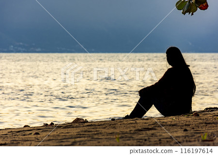 Girl sitting in front of the sea 116197614