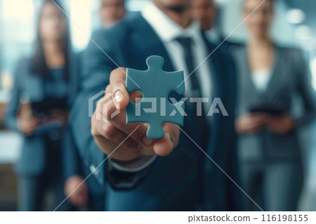 Businessman holding puzzle piece representing teamwork and problem solving 116198155