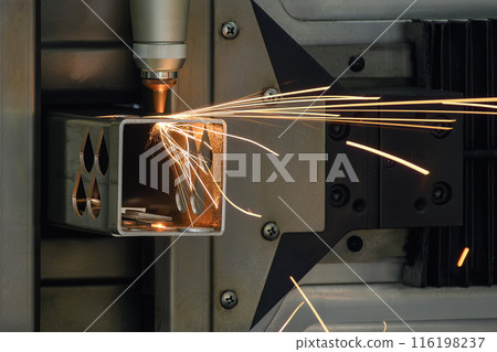 Close up scene the fiber laser cutting machine cut the square shape stainless steel tube with sparkling light. 116198237