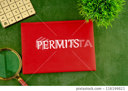 Business concept. The text PERMITS. on a red business notebook on a gorgeous green background Business concept. The text PERMITS. on a red business notebook on a gorgeous green background 116199821