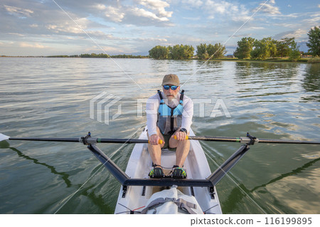 senior man in a rowing shell on a calm lake in Colorado in summer scenery senior man in a rowing shell on a calm lake in Colorado in summer scenery 116199895