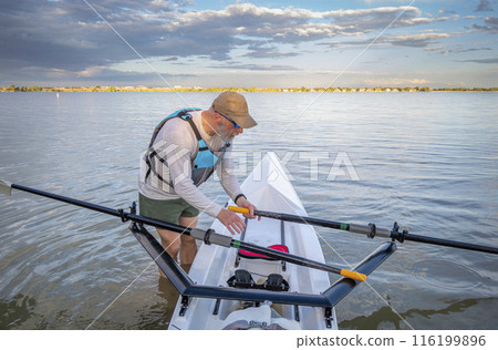 senior man in a rowing shell on a calm lake in Colorado in summer scenery senior man in a rowing shell on a calm lake in Colorado in summer scenery 116199896