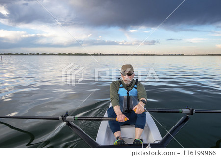 senior man in a rowing shell on a calm lake in Colorado senior man in a rowing shell on a calm lake in Colorado 116199966