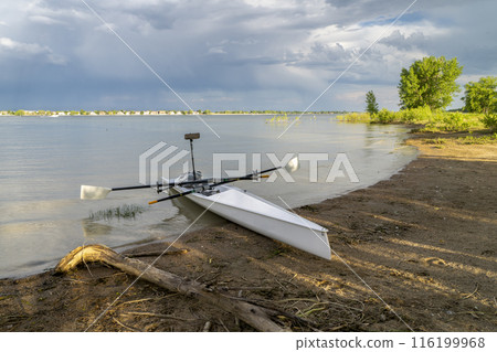 Coastal rowing shell on a shore of Boyd Lake in northern Colorado in early spring scenery. Coastal rowing shell on a shore of Boyd Lake in northern Colorado in early spring scenery. 116199968