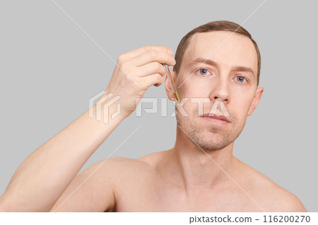 Man skin care routine. Oil pipette near male face. Hair serum product. Haircare 116200270