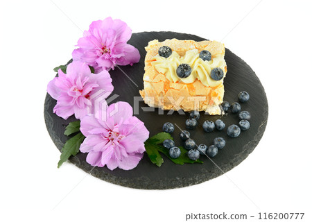 Meringue cake with blueberries on a slate tray isolated on white. 116200777