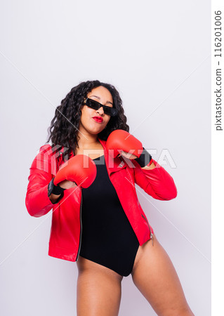 African oversize woman with boxing gloves on studio background, beautiful dark-skinned female boxer 116201006