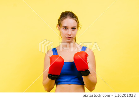 Young tired woman in sportswear and boxing gloves standing isolated on white yellow background. 116201028
