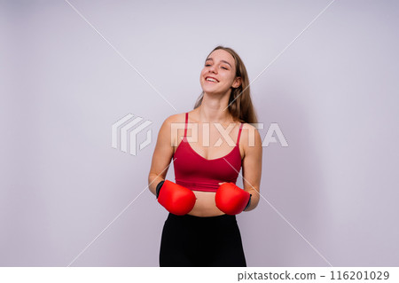 Young tired woman in sportswear and boxing gloves standing isolated on white yellow background. 116201029