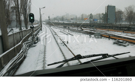 The train goes to the green light. Snow-covered subway tracks. Public transport in the great city. The train goes to the green light. Snow-covered subway tracks. Public transport in the great city. 116201860