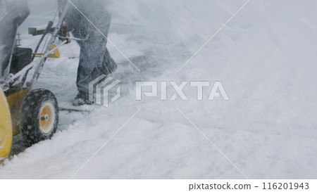 A man removes snow with a snowplow. Difficult weather conditions. 116201943