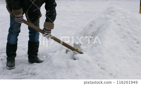 Janitor cleans snow of shovel. Janitor cleans the road from snow. Janitor cleans snow of shovel. Janitor cleans the road from snow. 116201949