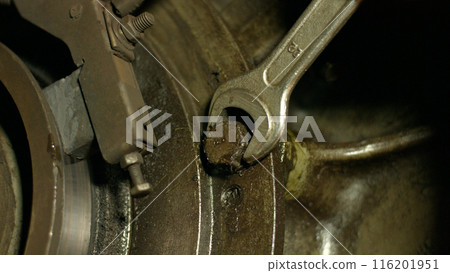 Engine repair. Mechanic tightening the screws. Repair of equipment. Mechanic repairing a car. 116201951