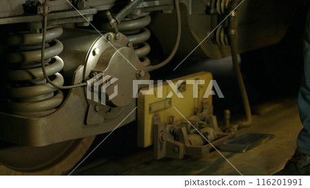 Checking the wheels and braking system of the metro. A technician inspects the metro wheels and brakes for necessary repairs. 116201991