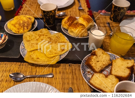 Moroccan breakfast ftour, msemen, baghrir, orange juice, pastries, bread basket, fried eggs, cheese cubes 116202684